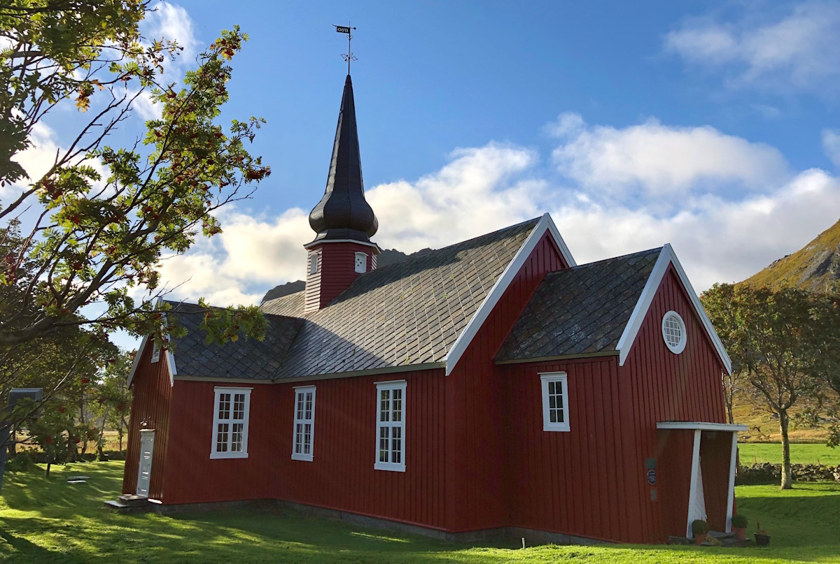Flakstad kirke i blå himmelen om sommer. Foto.